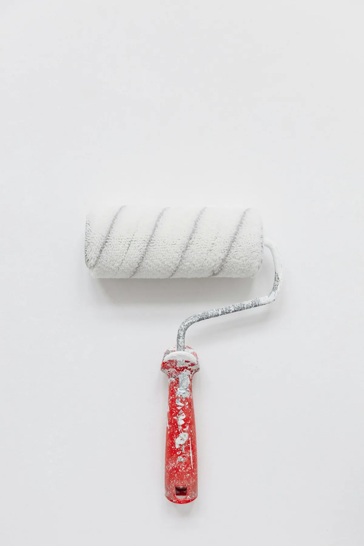 Paint roller applying a fresh white coat to an interior wall